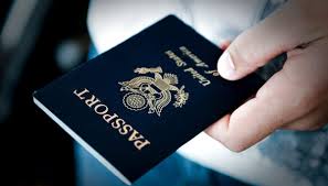 A person holding a passport in their hand, ready for travel or identification purposes.
